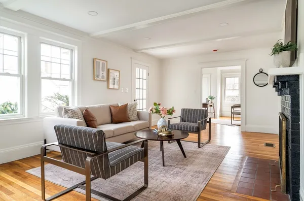 a living room with furniture wooden floor and a window