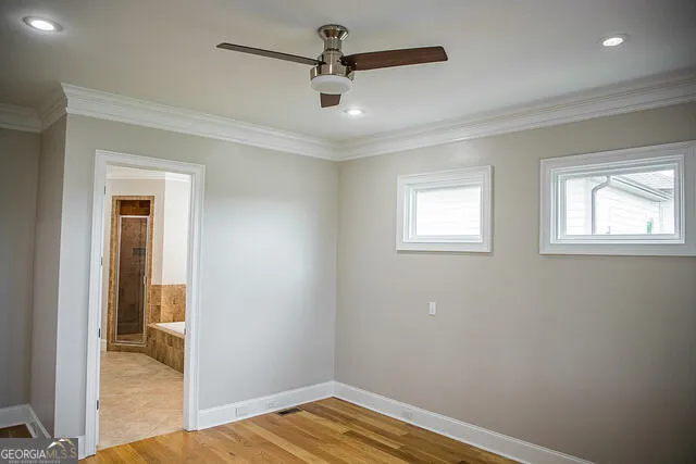 a view of a room with a hanging light and hardwood floor
