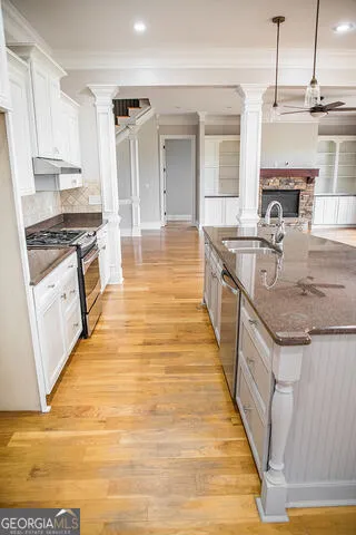 a large kitchen with granite countertop a stove and a sink