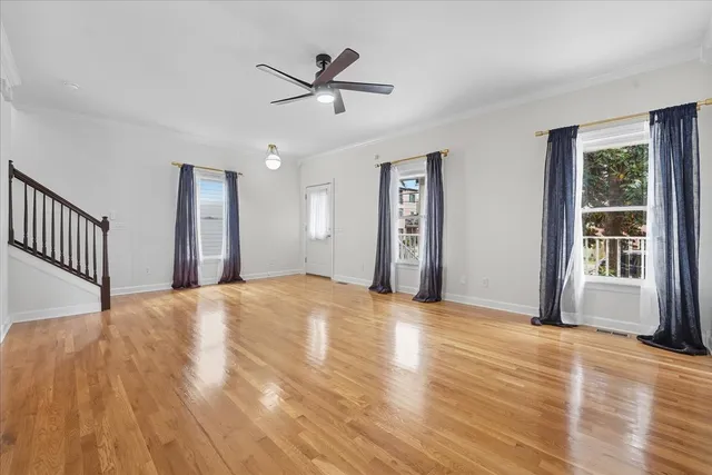 a view of a livingroom with wooden floor and a ceiling fan