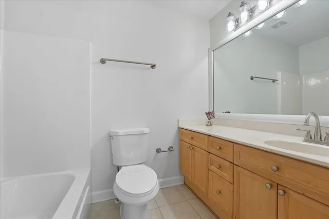 a bathroom with a granite countertop sink a toilet and a bathtub