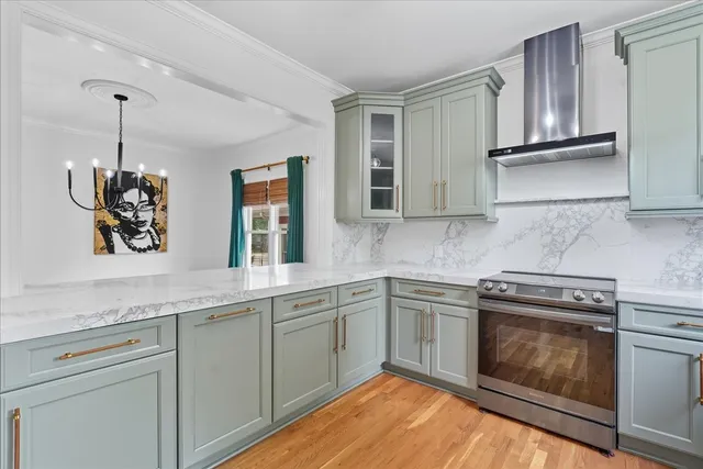 a kitchen with granite countertop stainless steel appliances a stove sink and cabinets