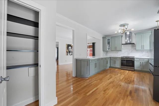 a kitchen with stainless steel appliances cabinets and wooden floor
