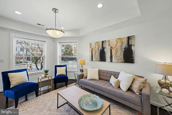 a living room with furniture a chandelier and a window
