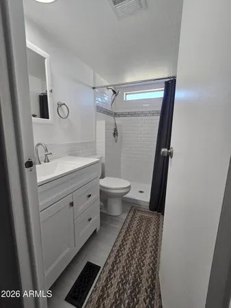 a bathroom with a sink and mirror with toilet