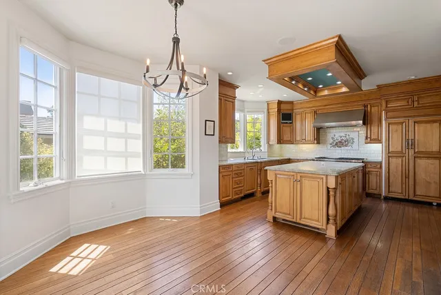 a kitchen with stainless steel appliances granite countertop wooden floors and white cabinets