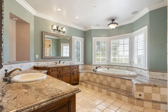 a spacious bathroom with a granite countertop tub sink and mirror