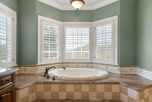 a bathroom with granite countertop a sink and a bathtub