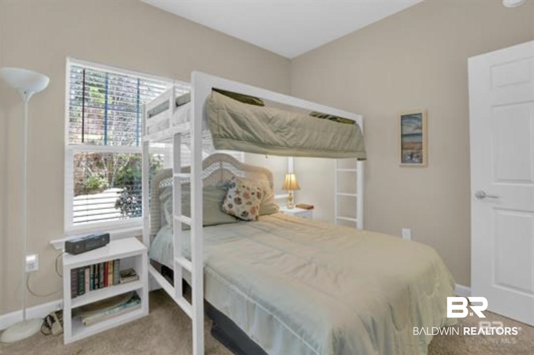 430 West Fort Morgan Road Gulf Shores, AL 36542 - Photo 20 of 27 Bedroom featuring a white bunk bed with integrated ladder, a window with horizontal blinds, neutral wall paint, and carpet flooring