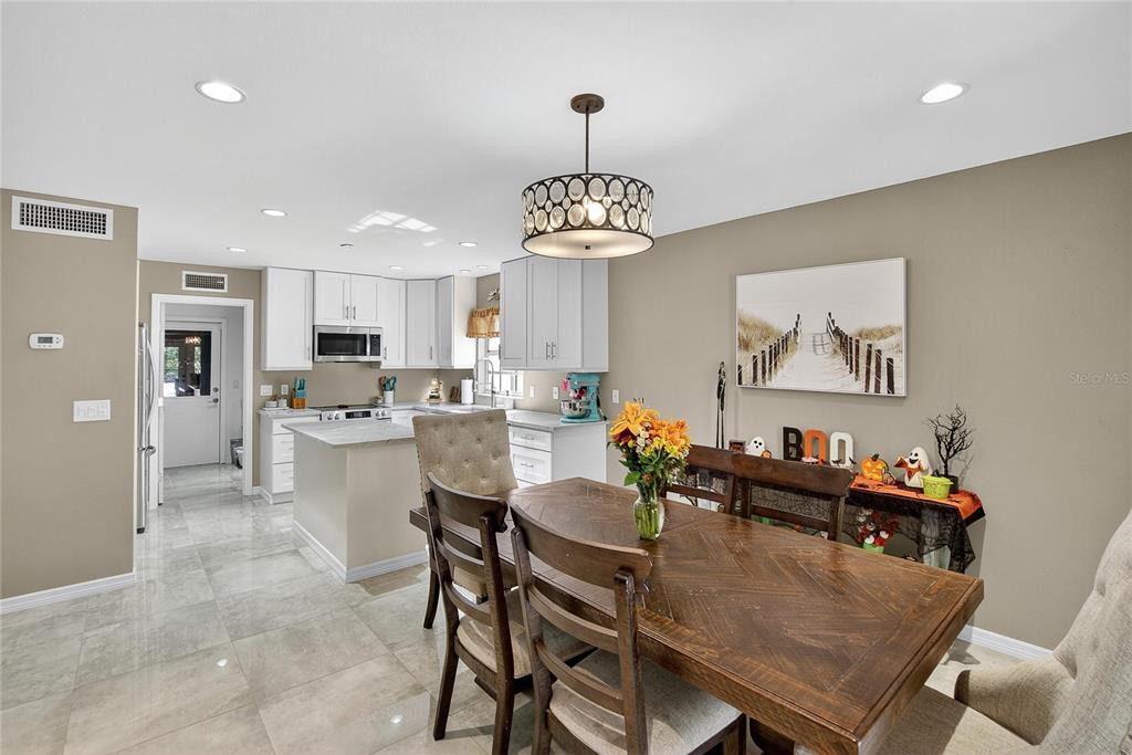3309 Timberlee Road Wimauma, FL 33598 - Photo 11 of 56 a view of a dining room with furniture a kitchen and chandelier