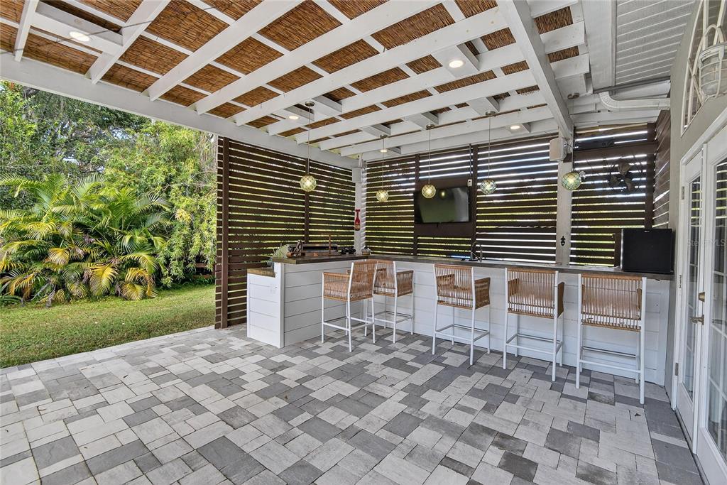 3309 Timberlee Road Wimauma, FL 33598 - Photo 29 of 56 a porch with a wooden bench in front of a house
