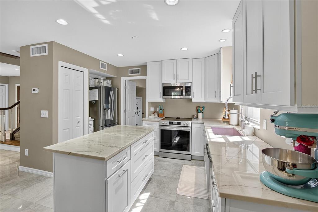 3309 Timberlee Road Wimauma, FL 33598 - Photo 9 of 56 a kitchen with kitchen island granite countertop a stove sink and cabinets