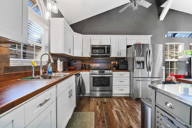 a kitchen with stainless steel appliances a refrigerator sink and microwave