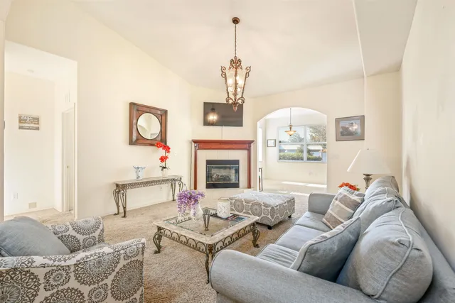 a living room with furniture a fireplace and a chandelier