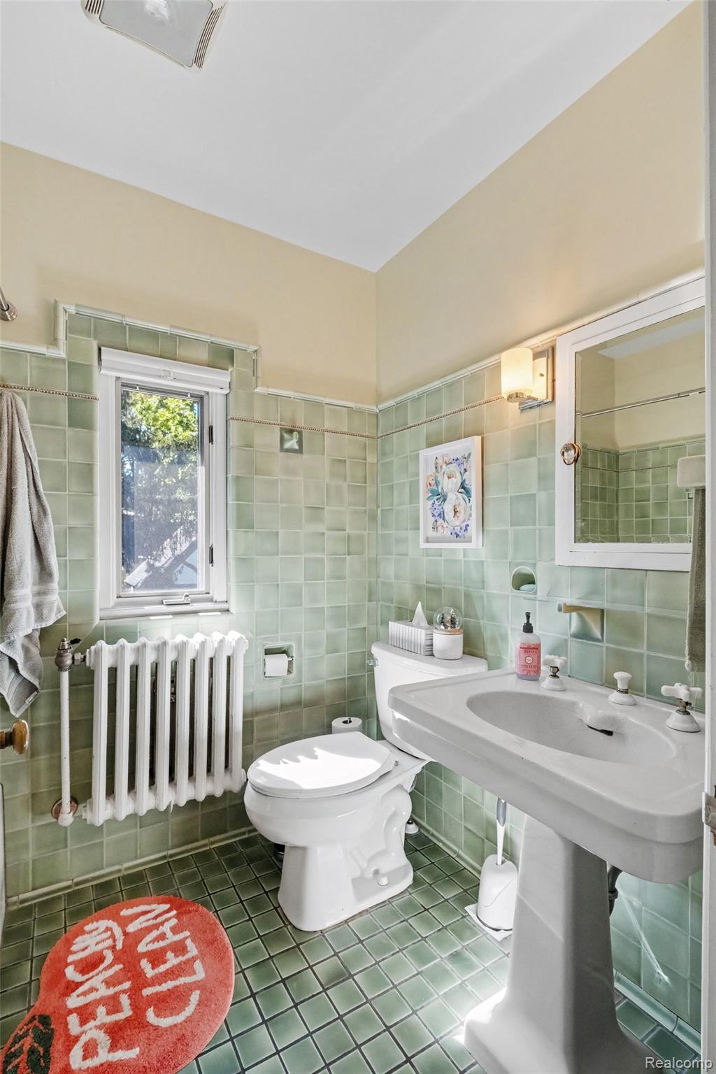 2030 Hampden Road Flint, MI 48503 - Photo 25 of 34 Green tile flooring and wainscoting, white pedestal sink, white toilet, and a window with natural light