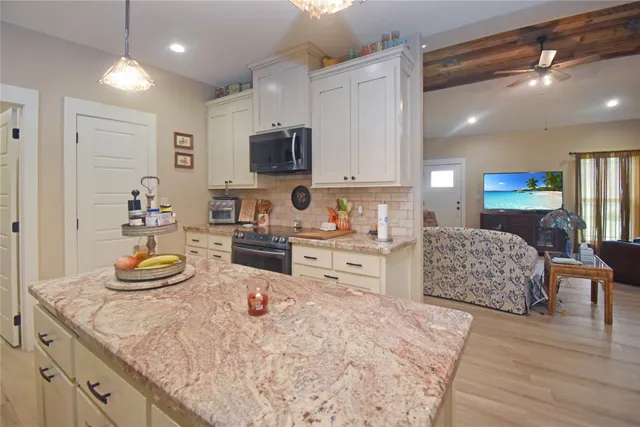 a kitchen with stainless steel appliances kitchen island granite countertop a sink and cabinets