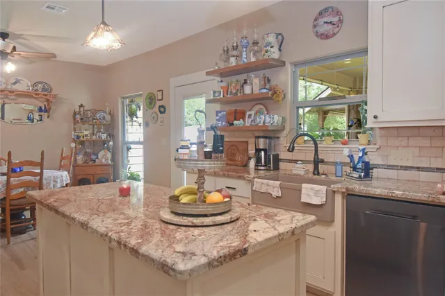 a kitchen with a sink a window and dining table