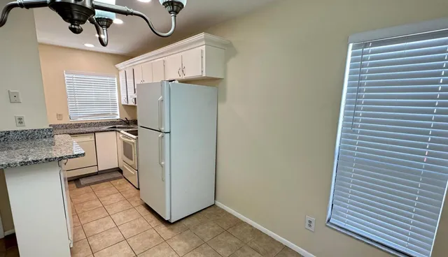 a kitchen with stainless steel appliances granite countertop a refrigerator and a stove