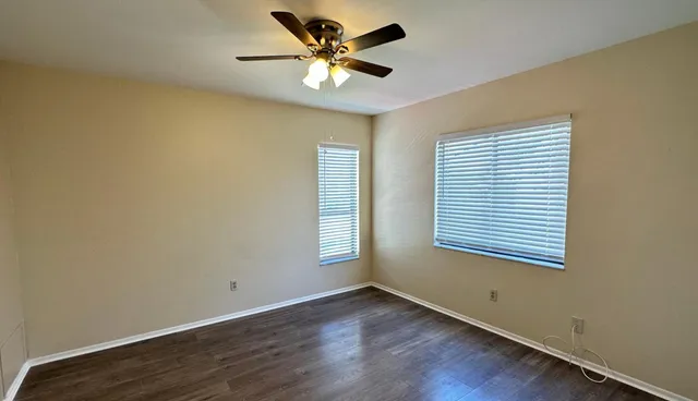 an empty room with a window and a fan