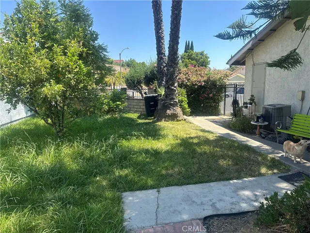 a view of a patio with table and chairs potted plants and large tree
