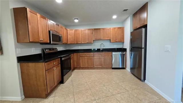 a kitchen with stainless steel appliances granite countertop a stove top oven a sink and dishwasher