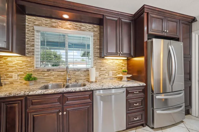 a kitchen with granite countertop a refrigerator and a sink