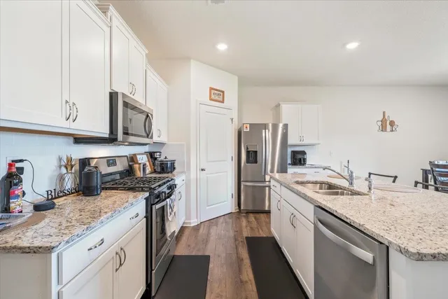 a kitchen with stainless steel appliances granite countertop a lot of counter space and wooden floors