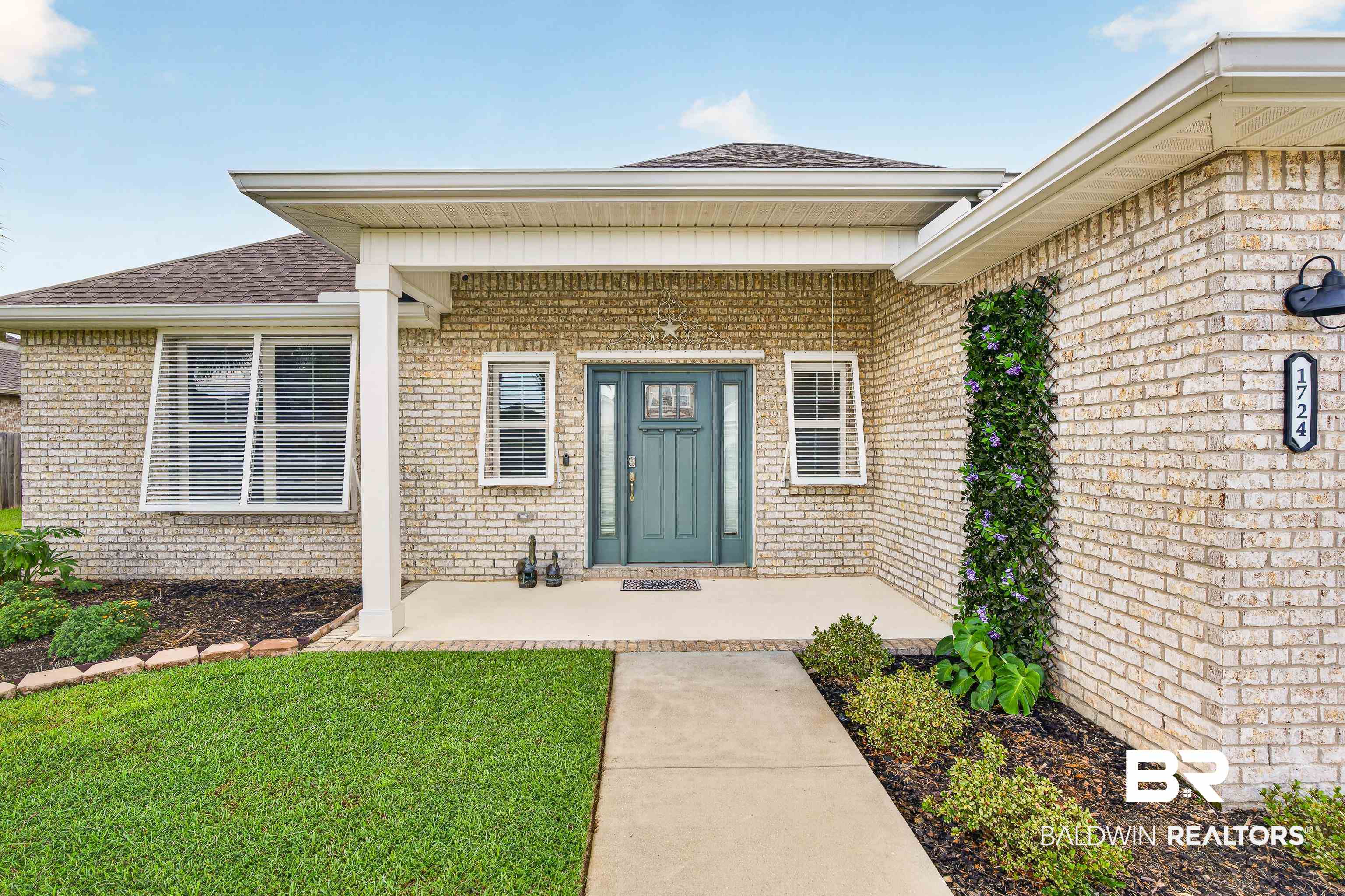 1724 Partridge Street Foley, AL 36535 - Photo 8 of 62 Light-colored brick exterior featuring a covered front entry with white columns and a teal front door with frosted glass detailing