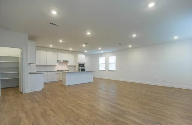 a view of kitchen with wooden floor and electronic appliances