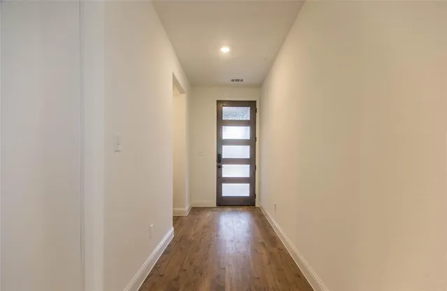 a view of a hallway with wooden floor and entryway