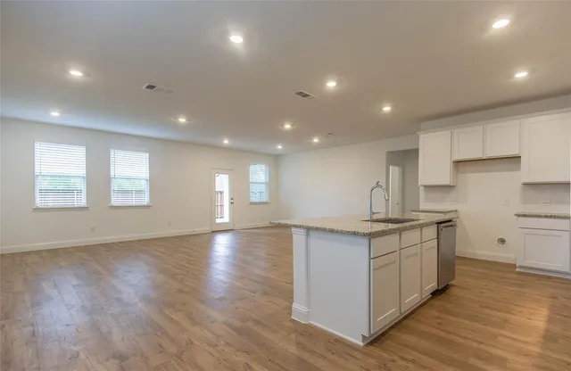 a kitchen with stainless steel appliances granite countertop a sink stove and wooden floor