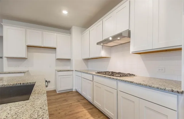 a kitchen with stainless steel appliances granite countertop a sink and cabinets