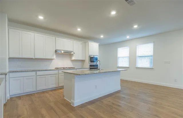 a kitchen with granite countertop white cabinets and white appliances