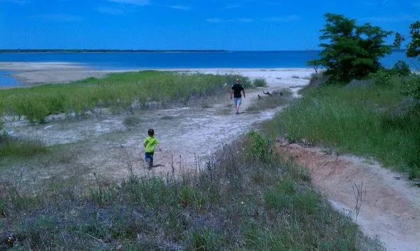 a view of a lake with beach and outdoor space