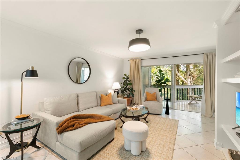 614 Wiggins Bay Drive Naples, FL 34110 - Photo 1 of 35 Living room with light tile patterned floors and crown molding