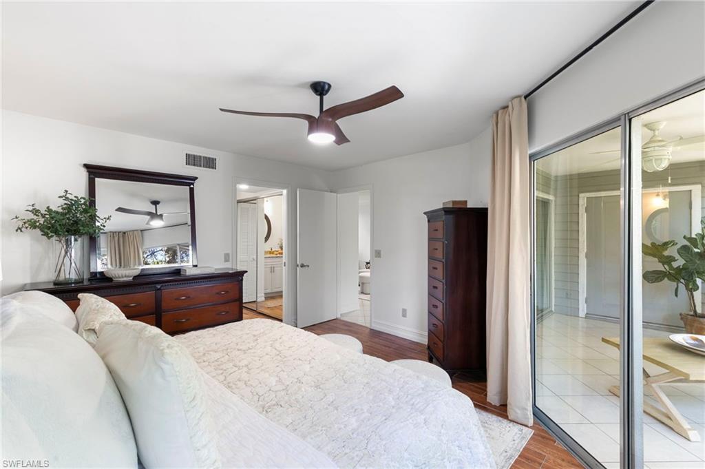 614 Wiggins Bay Drive Naples, FL 34110 - Photo 13 of 35 Bedroom with light wood finished floors, a ceiling fan, and ensuite bath