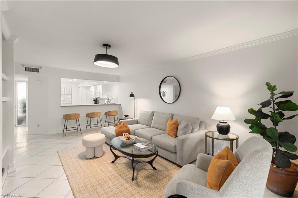 614 Wiggins Bay Drive Naples, FL 34110 - Photo 4 of 35 Living area with light tile patterned floors and crown molding