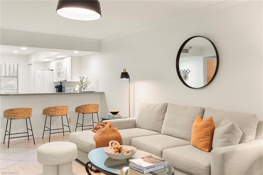 614 Wiggins Bay Drive Naples, FL 34110 - Photo 5 of 35 Living room featuring light tile patterned floors, crown molding, and recessed lighting