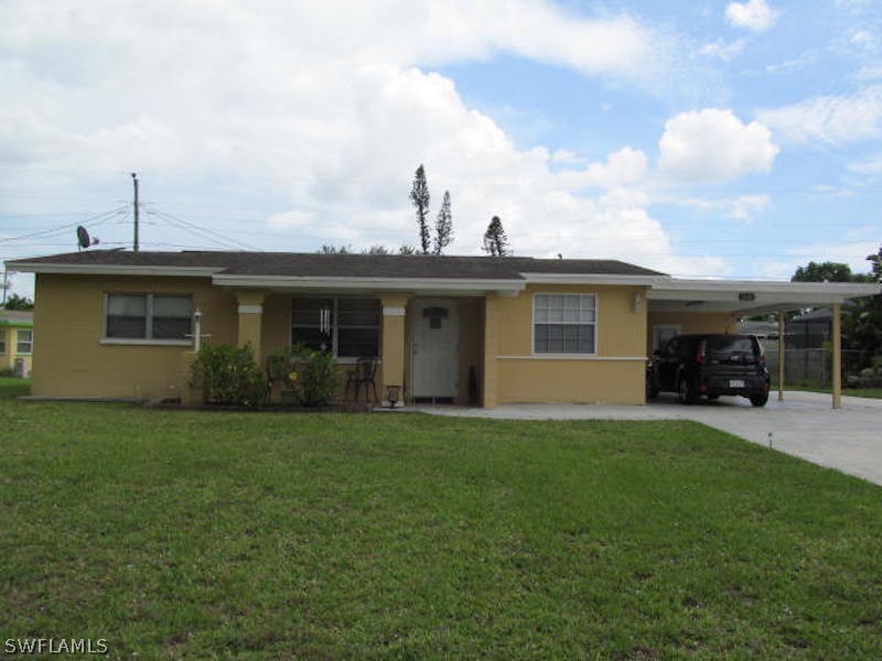 a front view of a house with a garden and yard