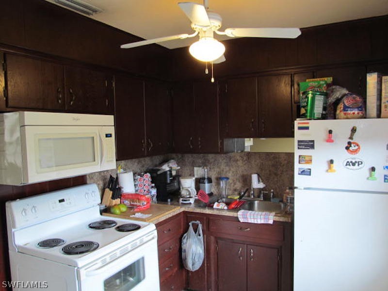 308 East Penn Road Lehigh Acres, FL 33936 - Photo 8 of 15 a kitchen with a sink a stove and cabinets