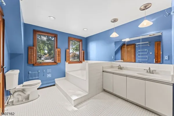 a bathroom with a bathtub a mirror and a shower
