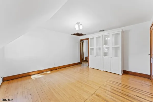 a view of a bedroom with wooden floor and a window