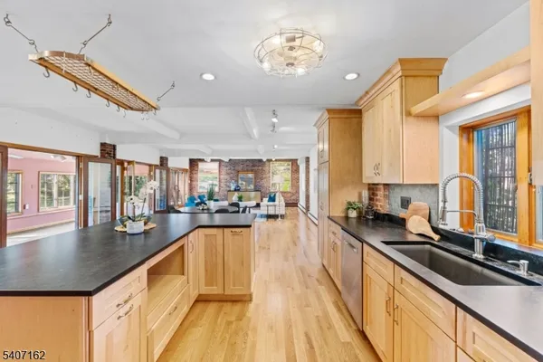 a kitchen with stainless steel appliances granite countertop a sink a stove and a refrigerator