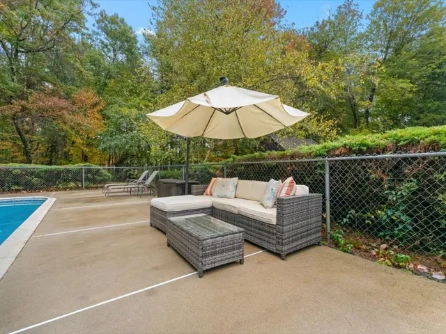 a view of a roof deck with couches and umbrella