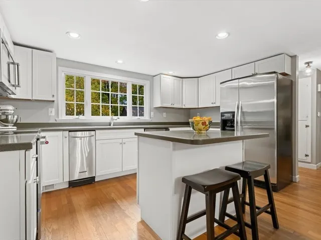 a kitchen with white cabinets and window