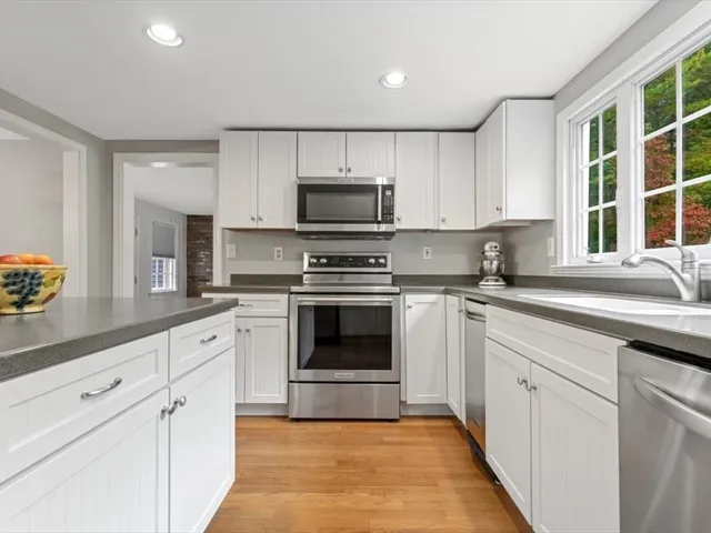 a kitchen with cabinets stainless steel appliances and a window