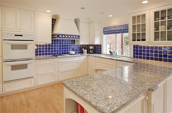 90 Baxter Road Brookline, MA 02445 - Photo 6 of 10 a kitchen with kitchen island a counter top space a sink stainless steel appliances and cabinets