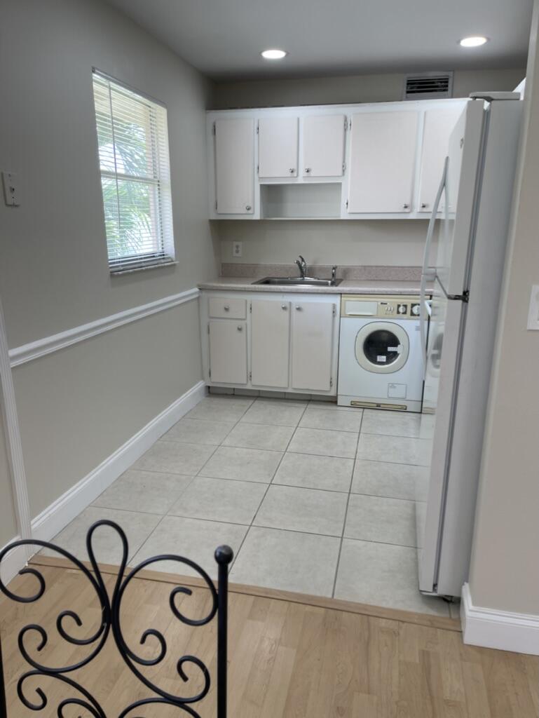 472 Saxony Way Delray Beach, FL 33446 - Photo 3 of 33 a kitchen with a refrigerator a stove top oven a sink and a window
