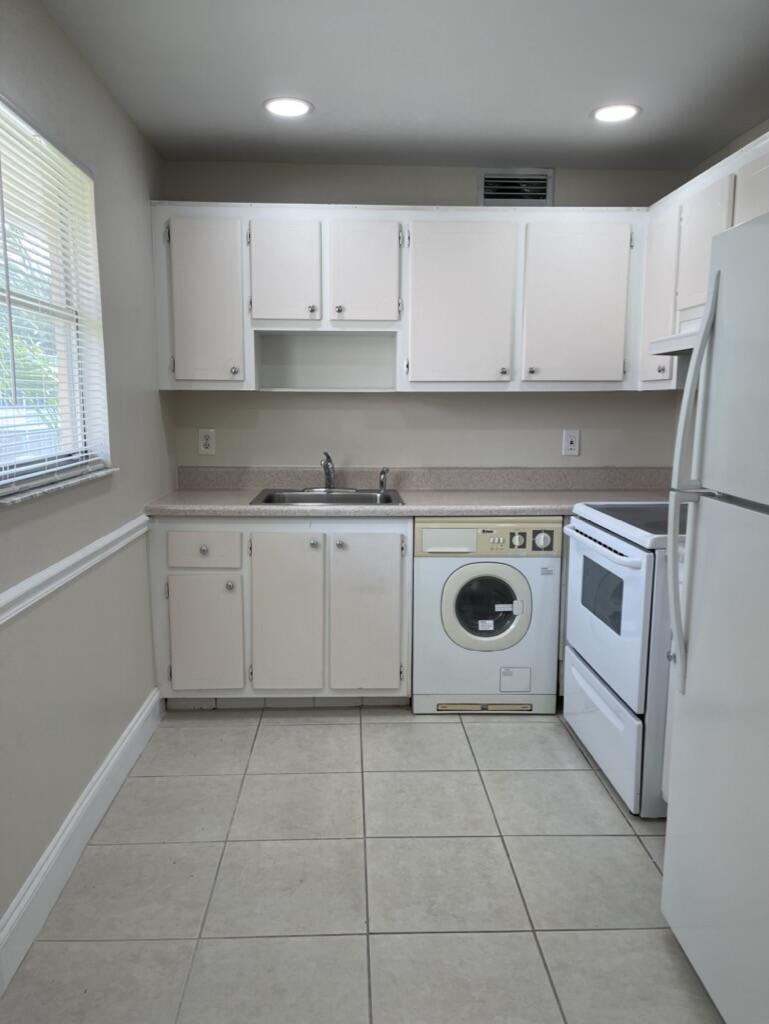 472 Saxony Way Delray Beach, FL 33446 - Photo 4 of 33 a kitchen with a stove sink and cabinets
