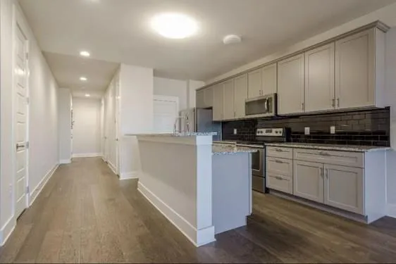 a kitchen with stainless steel appliances granite countertop a stove a sink and a refrigerator